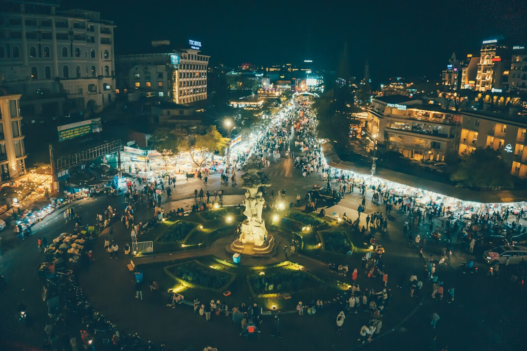 Crowd of people walking across a city square seen from above